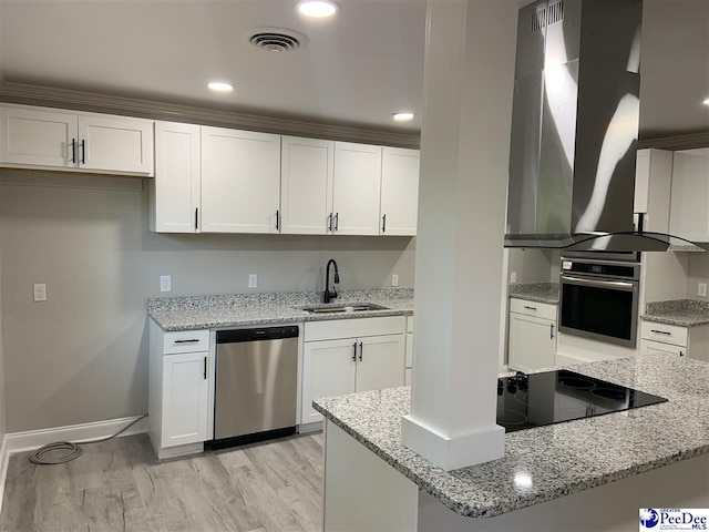 kitchen featuring sink, stainless steel appliances, light stone countertops, white cabinets, and wall chimney exhaust hood