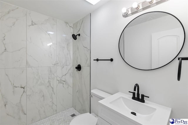bathroom with toilet, a marble finish shower, and vanity