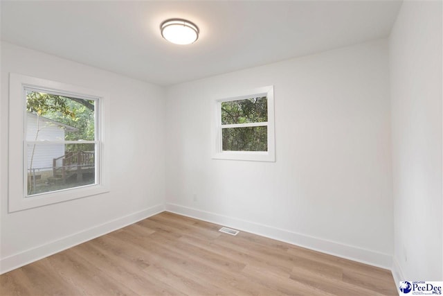 unfurnished room with visible vents, baseboards, and light wood-style floors