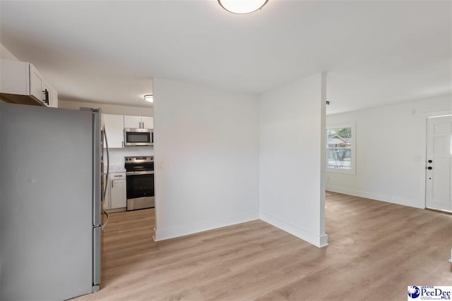 interior space with light wood finished floors and baseboards