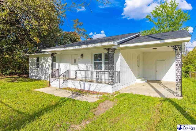 view of front facade featuring a porch, a carport, and a front lawn