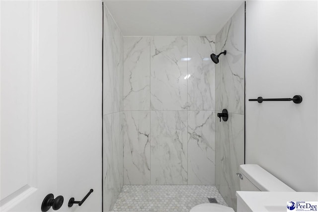 full bath featuring vanity, a marble finish shower, and toilet