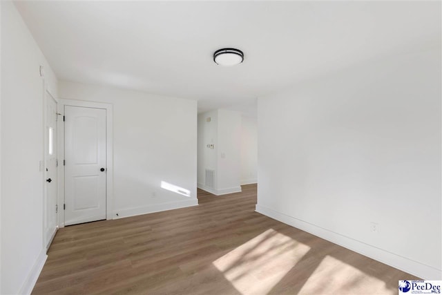 spare room with wood finished floors and baseboards
