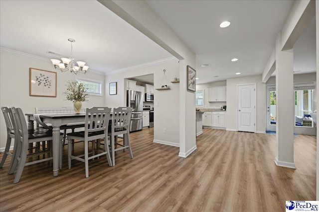 1757 Lake Wateree Dr, Florence, SC 29501 - dining room with light wood finished floors, a chandelier, crown molding, and recessed lighting