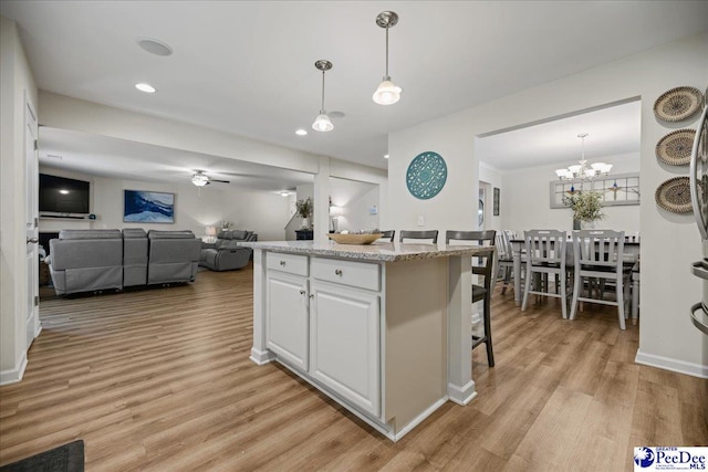 1757 Lake Wateree Dr, Florence, SC 29501 - kitchen featuring light wood finished floors, open floor plan, white cabinets, decorative light fixtures, and recessed lighting