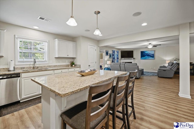 1757 Lake Wateree Dr, Florence, SC 29501 - kitchen with stainless steel dishwasher, open floor plan, light wood finished floors, ceiling fan, and recessed lighting