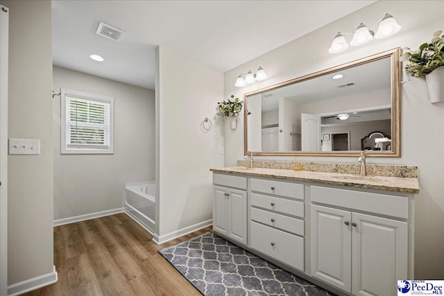 1757 Lake Wateree Dr, Florence, SC 29501 - full bathroom featuring double vanity, wood finished floors, a bath, and recessed lighting