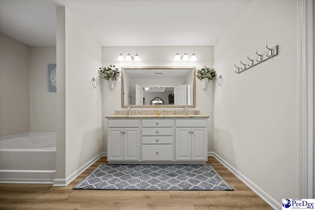 1757 Lake Wateree Dr, Florence, SC 29501 - bathroom featuring double vanity, wood finished floors, and a bath