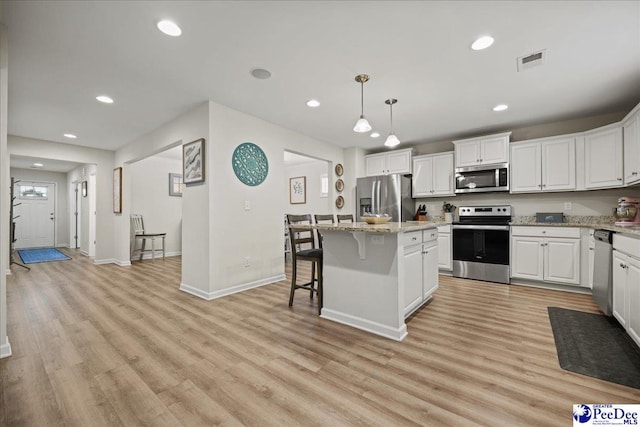 1757 Lake Wateree Dr, Florence, SC 29501 - kitchen featuring stainless steel appliances, recessed lighting, a breakfast bar, light wood-type flooring, and white cabinets