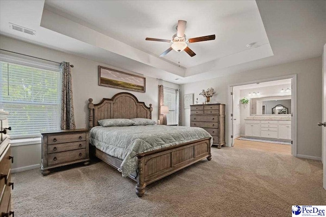 1757 Lake Wateree Dr, Florence, SC 29501 - bedroom with a tray ceiling, light colored carpet, ensuite bathroom, and ceiling fan