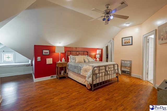bedroom featuring visible vents, baseboards, wood finished floors, and lofted ceiling