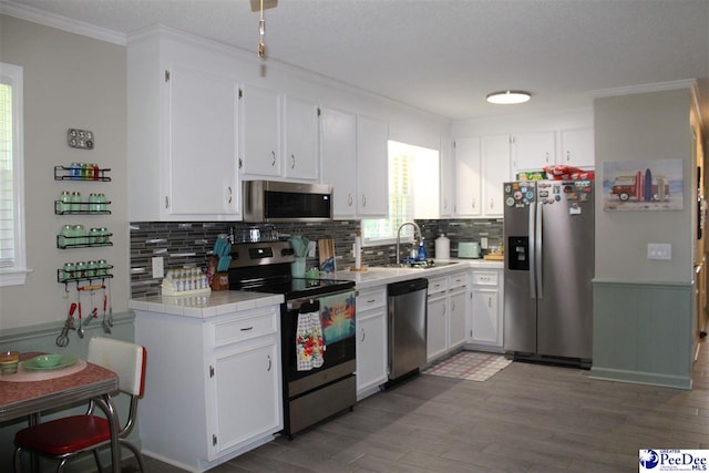 816 Madeira Ln, Florence, SC 29505 - kitchen with appliances with stainless steel finishes, tile counters, a sink, decorative backsplash, and crown molding