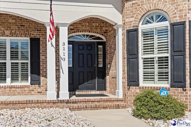 doorway to property with brick siding