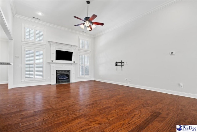 unfurnished living room featuring baseboards, a fireplace with flush hearth, ceiling fan, ornamental molding, and dark wood-type flooring