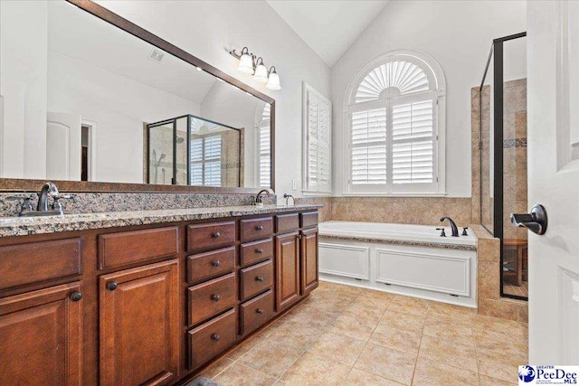 bathroom with double vanity, a stall shower, a sink, vaulted ceiling, and a bath