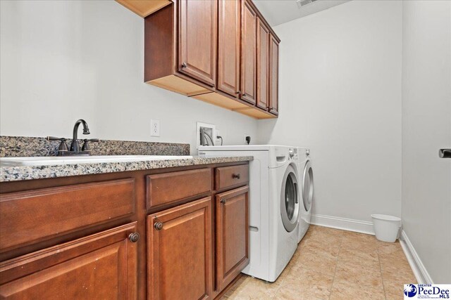 laundry room featuring washer and clothes dryer, cabinet space, baseboards, and light tile patterned flooring