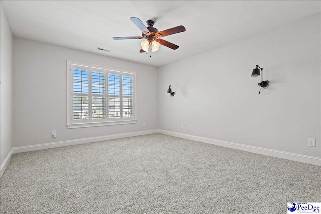 empty room with visible vents, baseboards, carpet floors, and ceiling fan