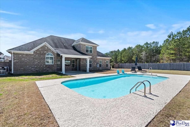 view of swimming pool featuring a fenced in pool, a patio, a lawn, and fence