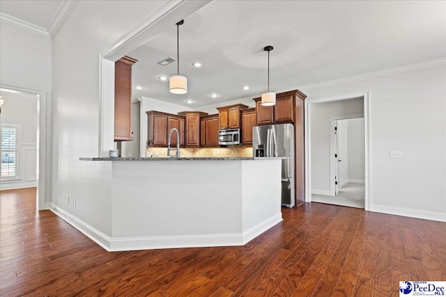 kitchen featuring stone counters, dark wood finished floors, ornamental molding, stainless steel appliances, and brown cabinets