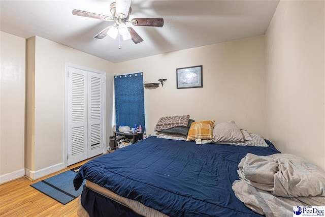 bedroom with hardwood / wood-style flooring, a closet, and ceiling fan