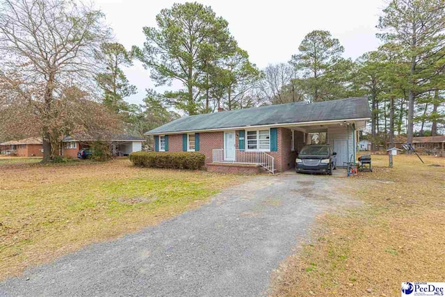 ranch-style house with a carport and a front lawn