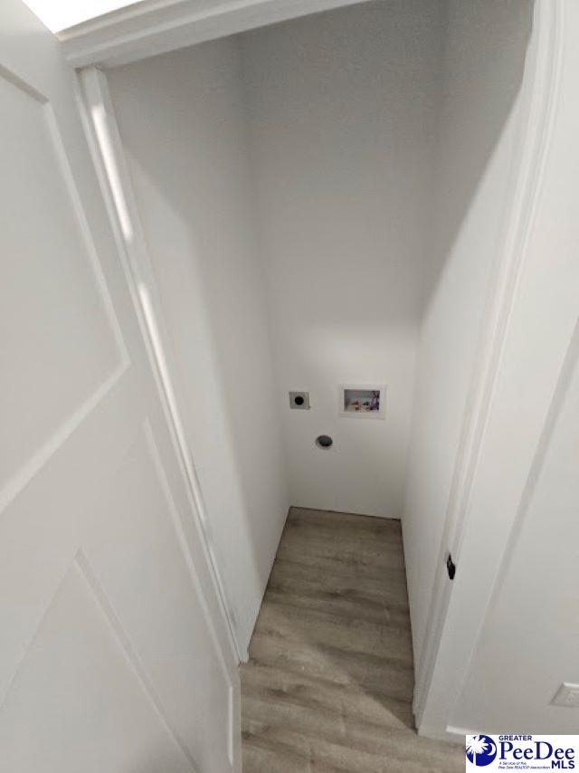 laundry area with electric dryer hookup, hookup for a washing machine, and light hardwood / wood-style flooring