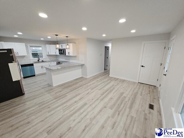 kitchen featuring appliances with stainless steel finishes, sink, white cabinets, hanging light fixtures, and kitchen peninsula