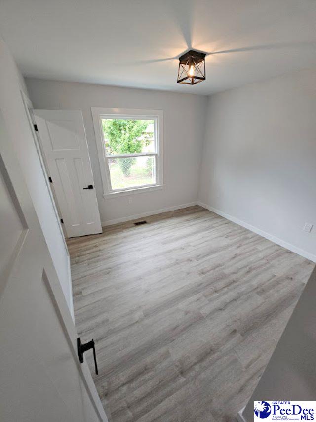 spare room with light wood-type flooring