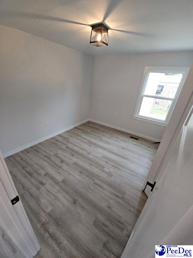 empty room with light hardwood / wood-style flooring