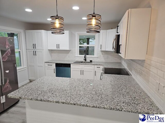 kitchen featuring appliances with stainless steel finishes, sink, white cabinets, and decorative light fixtures