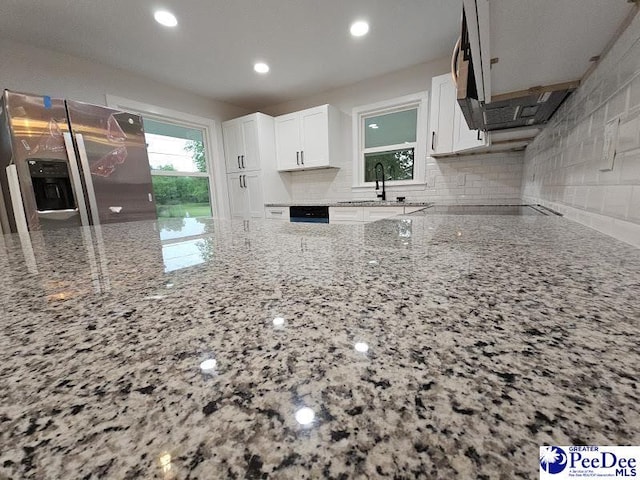 kitchen featuring white cabinetry, sink, and light stone counters