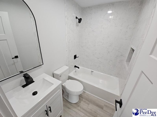 full bathroom with vanity, wood-type flooring, toilet, and tiled shower / bath