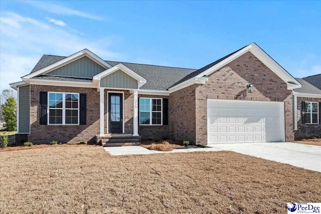 view of front facade with driveway, brick siding, a front lawn, and an attached garage