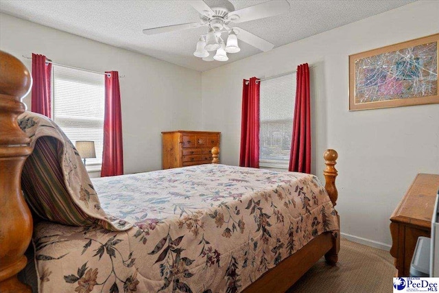 carpeted bedroom featuring baseboards, a ceiling fan, and a textured ceiling