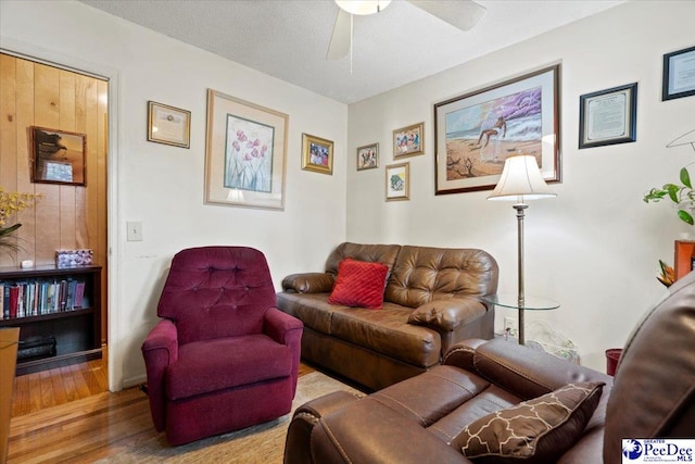 living area featuring ceiling fan, a textured ceiling, and wood finished floors