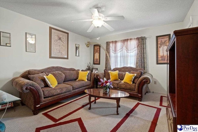 living room featuring arched walkways, a textured ceiling, a ceiling fan, and light colored carpet