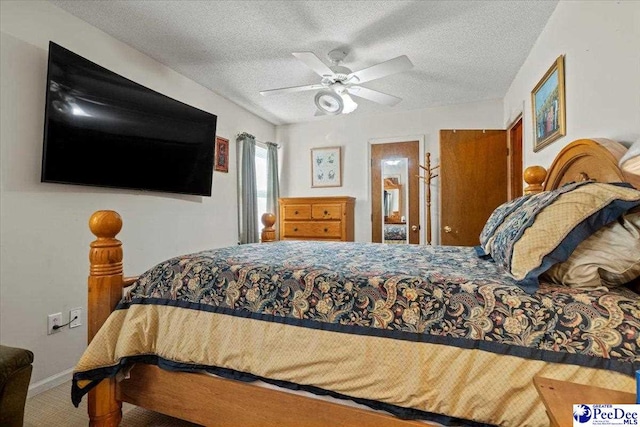 carpeted bedroom featuring ceiling fan, a textured ceiling, and baseboards