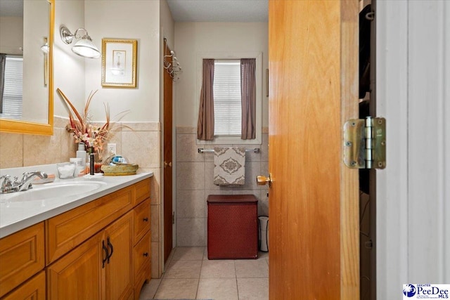 bathroom featuring wainscoting, vanity, tile walls, and tile patterned floors