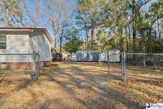 view of yard with fence, a storage unit, and an outdoor structure