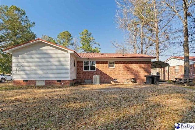 view of property exterior featuring crawl space, brick siding, central AC unit, and a detached carport