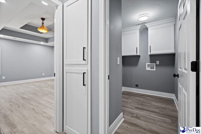 washroom featuring washer hookup, light hardwood / wood-style flooring, and cabinets