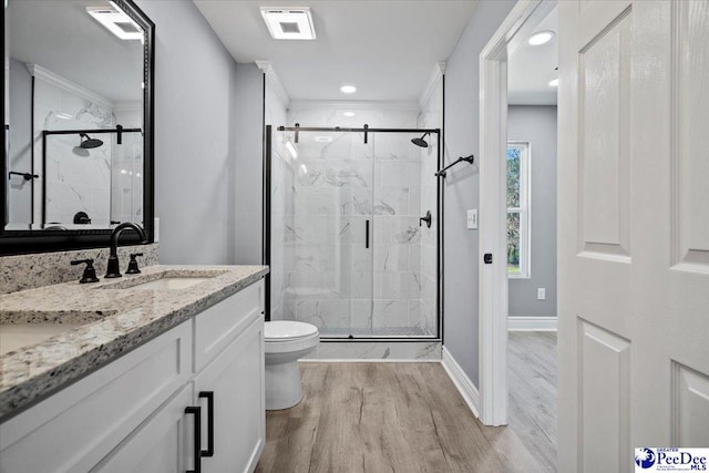 bathroom with wood-type flooring, toilet, an enclosed shower, and vanity