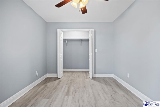 unfurnished bedroom featuring ceiling fan, light wood-type flooring, and a closet