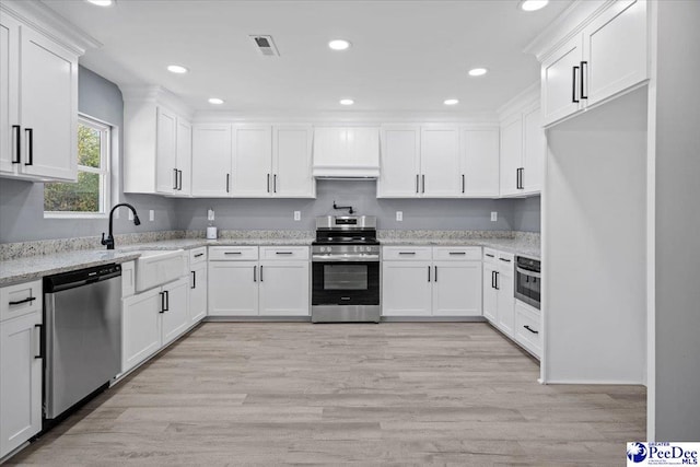 kitchen featuring white cabinetry, sink, light stone countertops, and appliances with stainless steel finishes