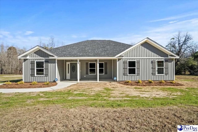 back of property with a yard and covered porch