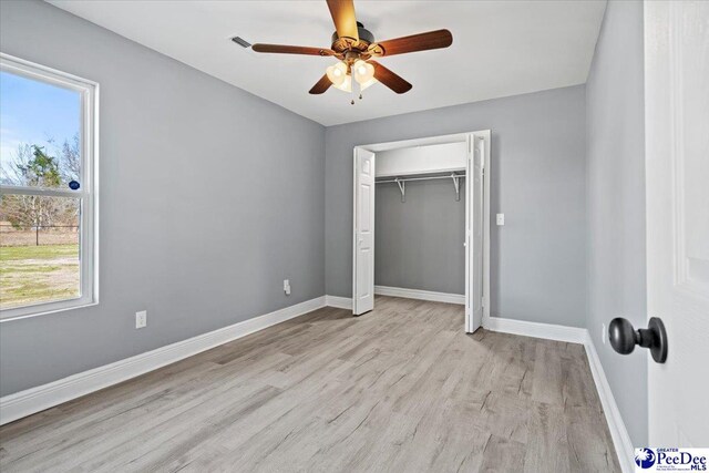 unfurnished bedroom with a closet, ceiling fan, and light wood-type flooring