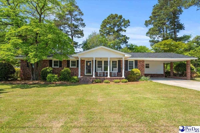 view of front facade with a front lawn, driveway, covered porch, and brick siding