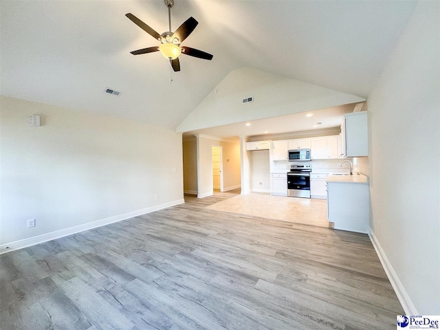 unfurnished living room with a sink, visible vents, light wood-type flooring, and baseboards