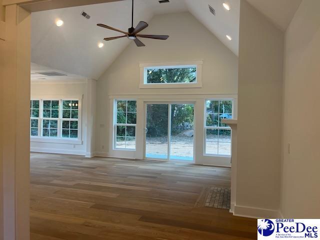 unfurnished living room with ceiling fan, high vaulted ceiling, and hardwood / wood-style floors