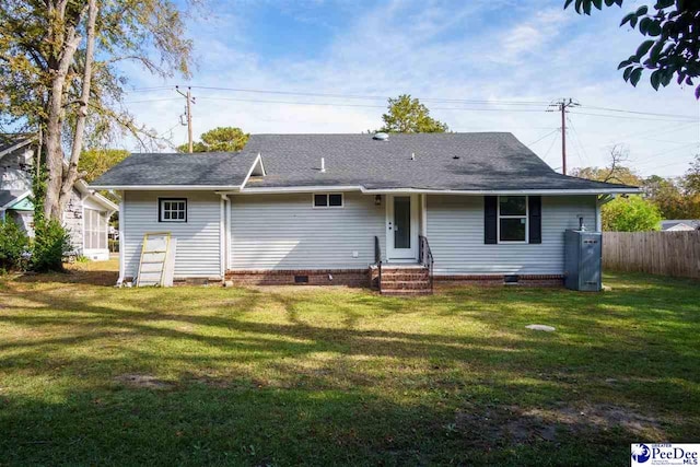 rear view of property with a lawn